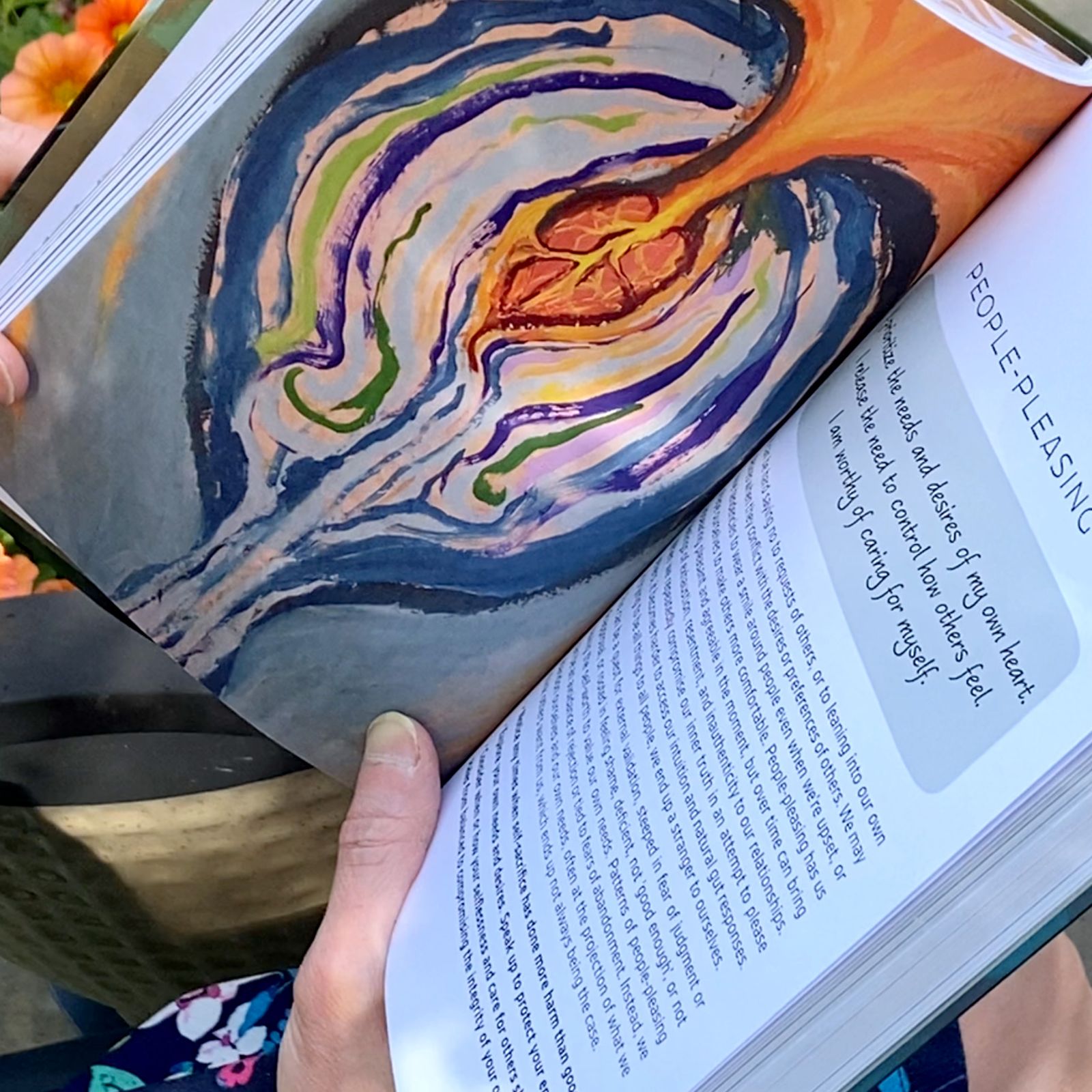 Photo of Wisdom of Wholeness: Shadow Work Journal, turned to the section titled "People-Pleasing" with a layered anatomical heart painting with golden yellow energy moving up and out.
