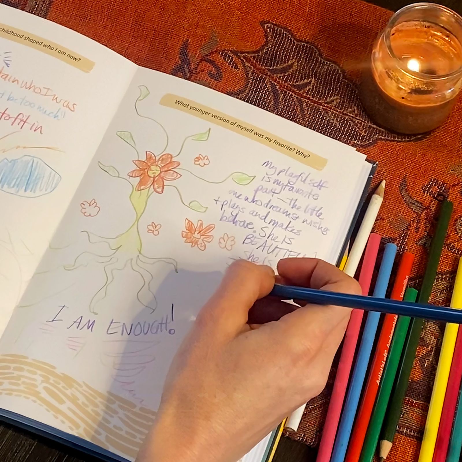 Hand drawing images with colored pencils and notes inside Wisdom of Wholeness: Shadow Work workbook.